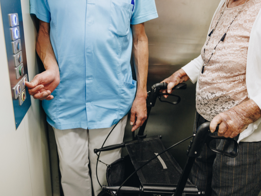 20 04 2023 Irishof Zorgpartners Lift Medewerker Closeup Bewoner Rollator