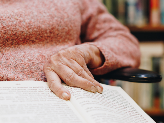 09 03 2023 Zorgpartners De Breeje Hendrick Bewoner Rolstoel Lezen Leeshoek Boeken Close Up Hand