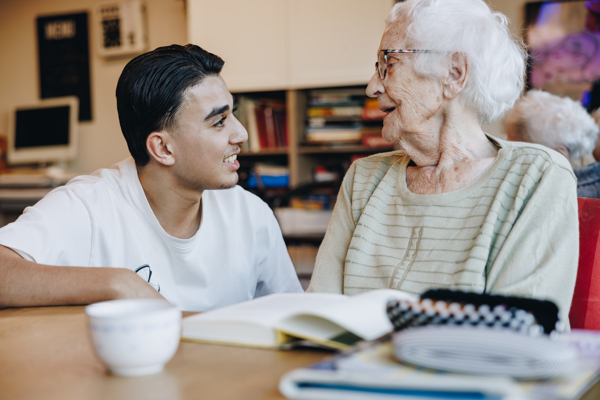 Ronssehof Bewoner Client Jongere Jongen Lachen Interactie Boek Kopje Tafel Stagiair