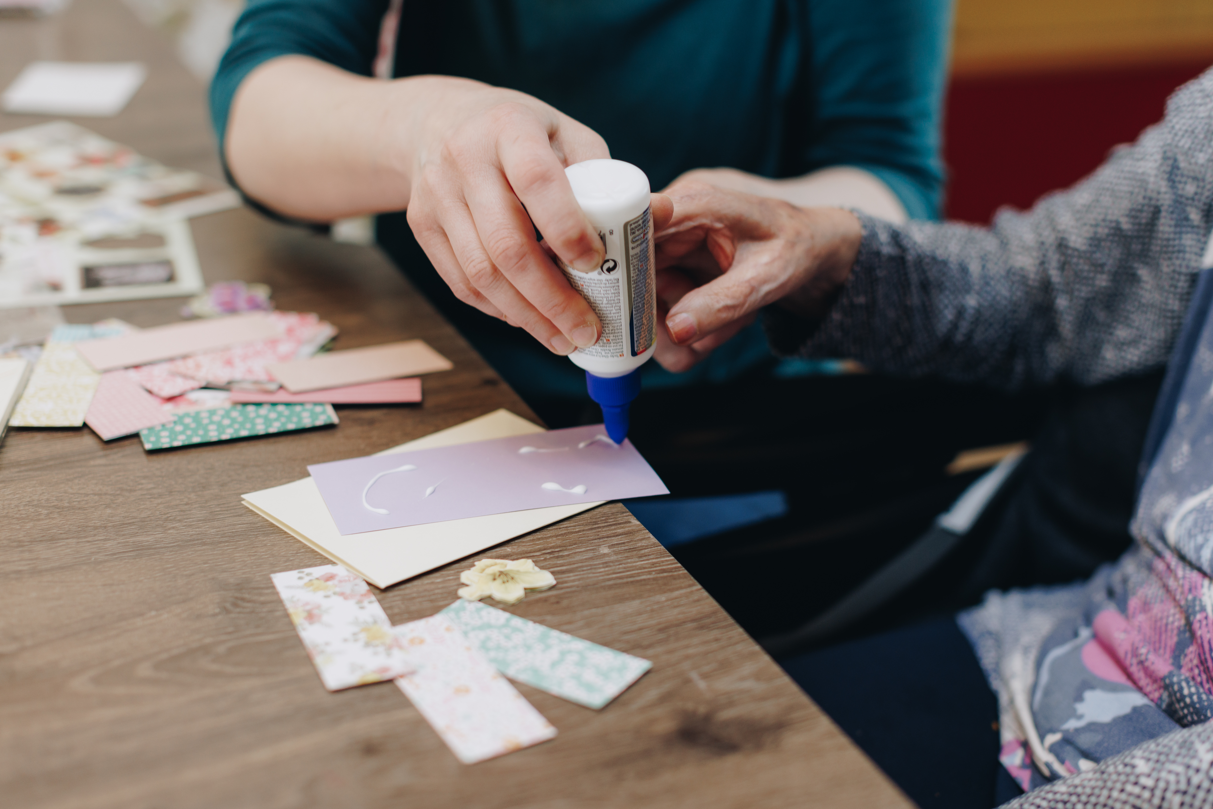 De Waterpoort Zorgpartners Bewoner Medewerker Welzijn Knutselen Papier Lijm Handen Close Up