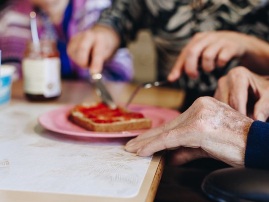 17 02 2023 Zorgpartner Slothoven Bewoner Medewerker Boterham Jam Eten Close Up Snijden
