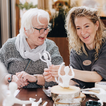 09 03 2023 Zorgpartners De Breeje Hendrick Bewoner Medewerker Welzijn Handwerken Activiteit Close Up Staand Lachen