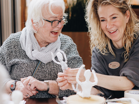 09 03 2023 Zorgpartners De Breeje Hendrick Bewoner Medewerker Welzijn Handwerken Activiteit Close Up Staand Lachen