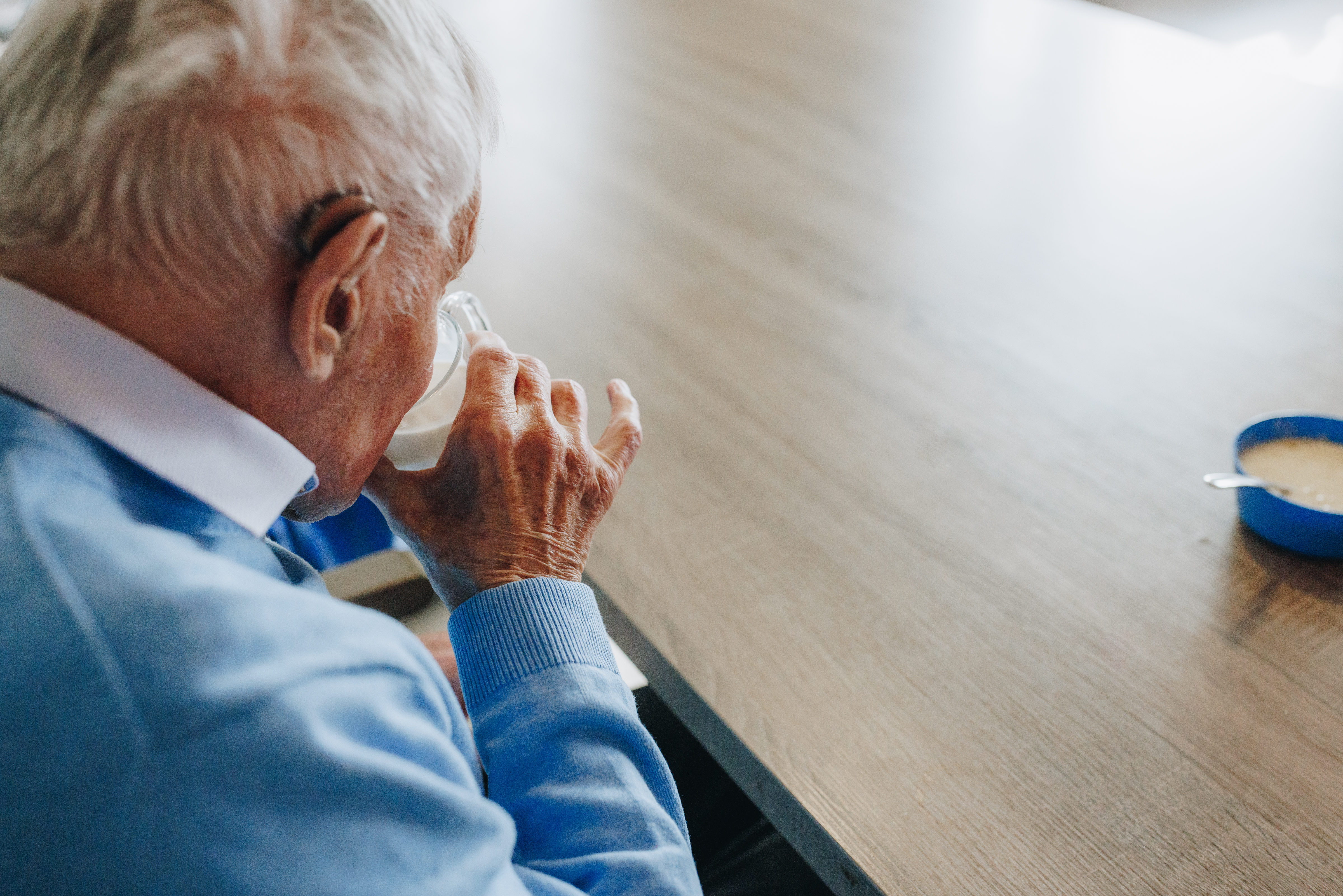 09 02 2023 Zorgpartners De Reehorst Bewoner Heer Drinken Tafel Gehoorapparaat