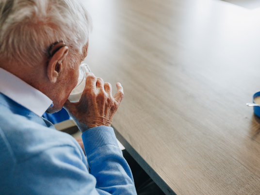 09 02 2023 Zorgpartners De Reehorst Bewoner Heer Drinken Tafel Gehoorapparaat